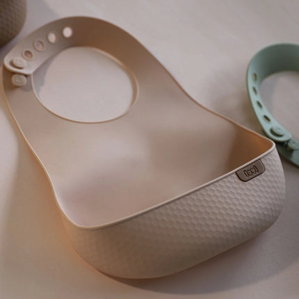 Silikonový bryndák s kapsou Nude